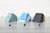 Pen holders, one shades of green, one blue and white, and one black and yellow on a gray table with a white background