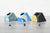 Pen holders, one shades of green, one blue and white, and one black and yellow on a gray table with a white background