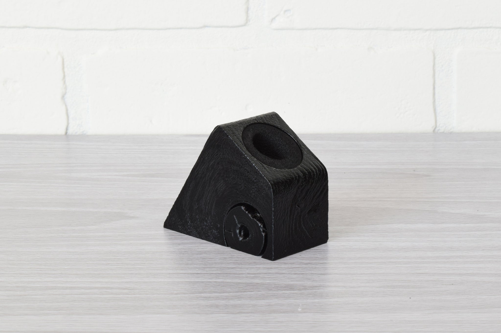 black pen holder on gray table with white background