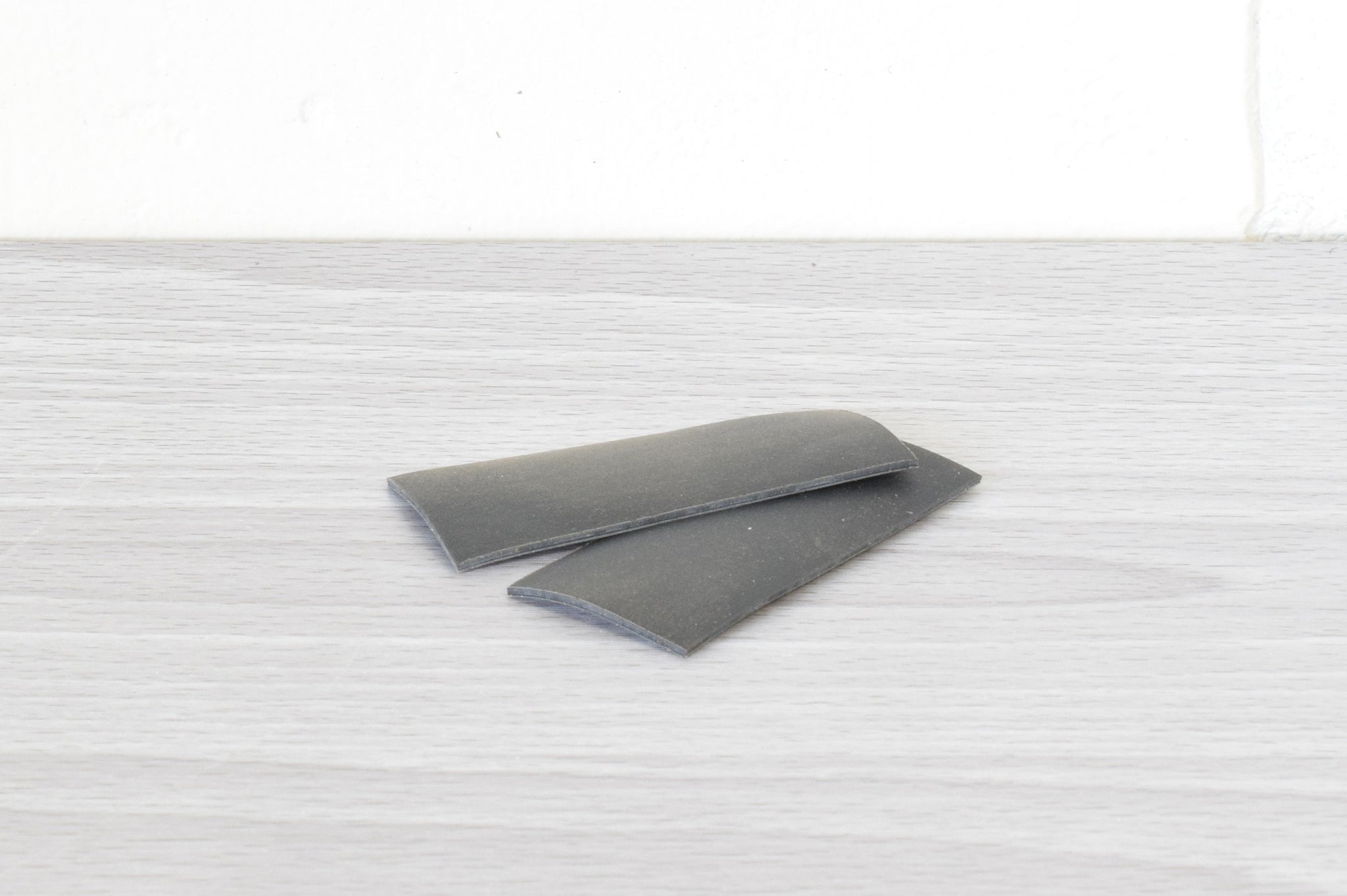 a set of black anti slip pads sitting on a gray table with a white background