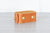 A tan Nomad Book Weight shown in the closed position, set on a gray tabletop with white background.