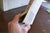 Has to look back at what has been hand holding an open book using a tan book clip to keep the pages open for ease of use