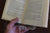 A book clip with a book in it being held by a hand