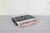 Gray felt book holder showing two books in it on a Gray surface with white background
