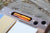 Detail image of the writewell lap desk showing the miscellaney niche holding fountain pens, two  penwells, the Readers kit, along with a notebook and a book