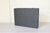 Gray fabric case on a light wooden surface with a white background