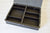 Black writewell storage case with compartments on a light wooden surface